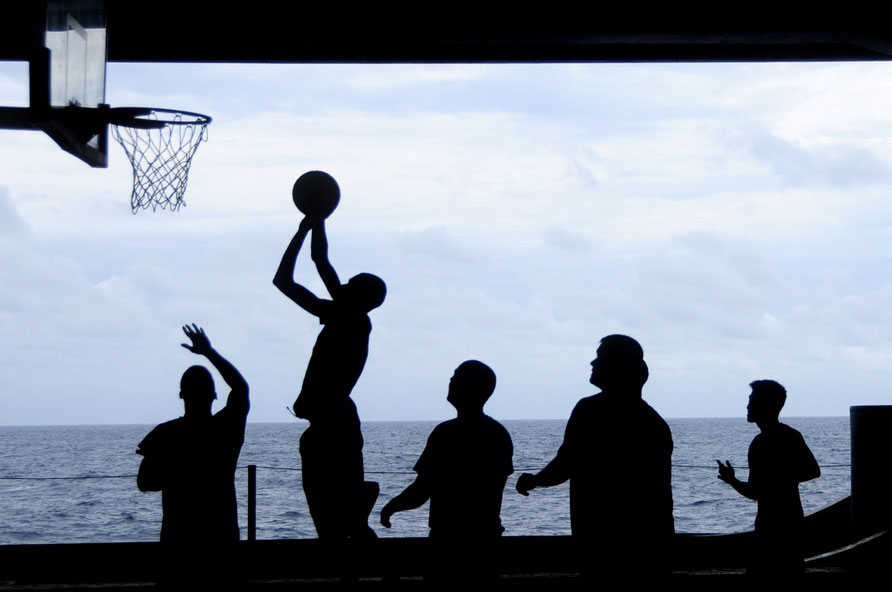 Silhouetten von Spielern vor dem Meer